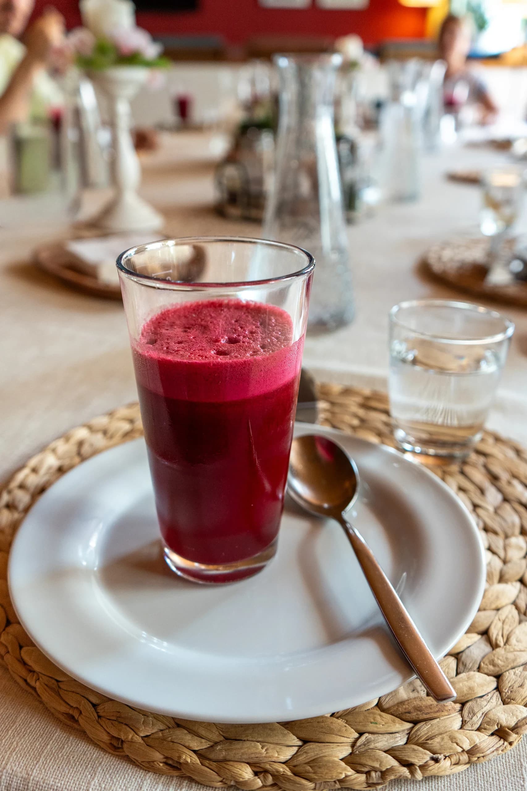 Glas frisch gepresster Rote-Bete-Saft auf dem gedeckten Tisch