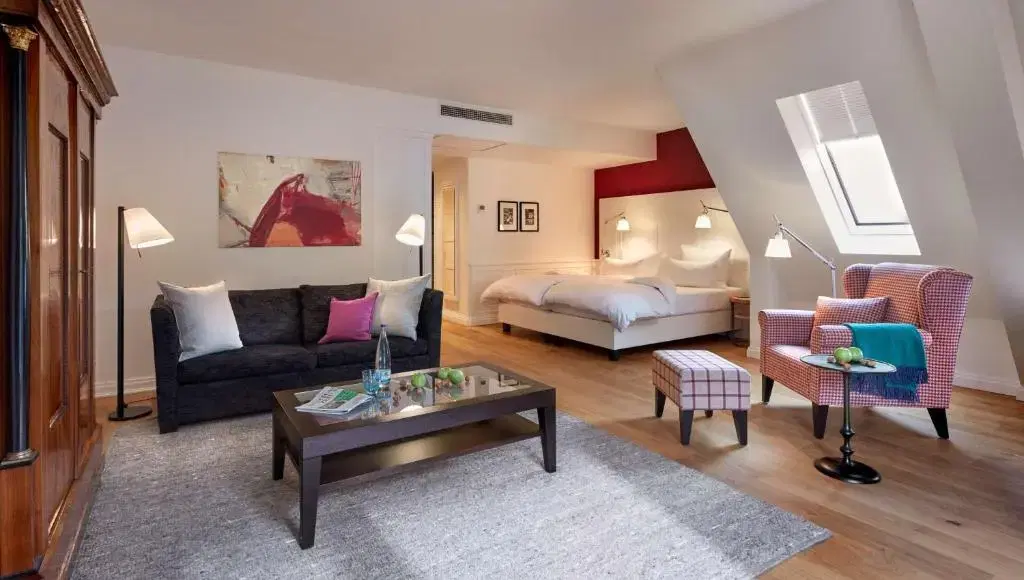 Modern eingerichtetes Zimmer mit Doppelbett und einem Sofa im Wohnbereich